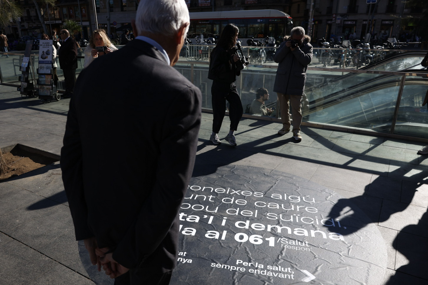 El conseller de Salut, Manel Balcells, a la plaça Universitat de Barcelona, mirant la imatge de la campanya.